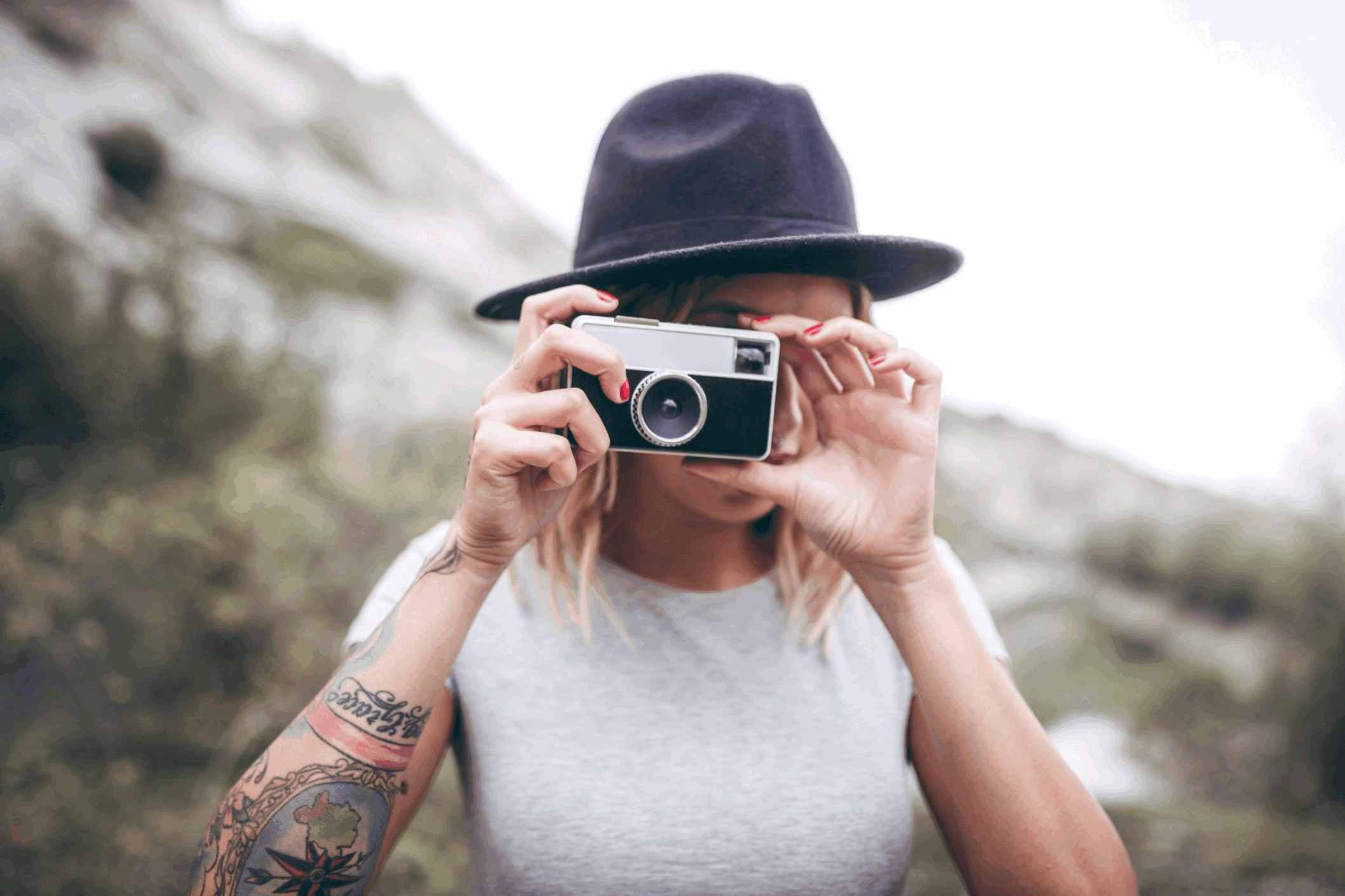 young hiking woman is taking pictures with her retro camera t20 P3rEwy